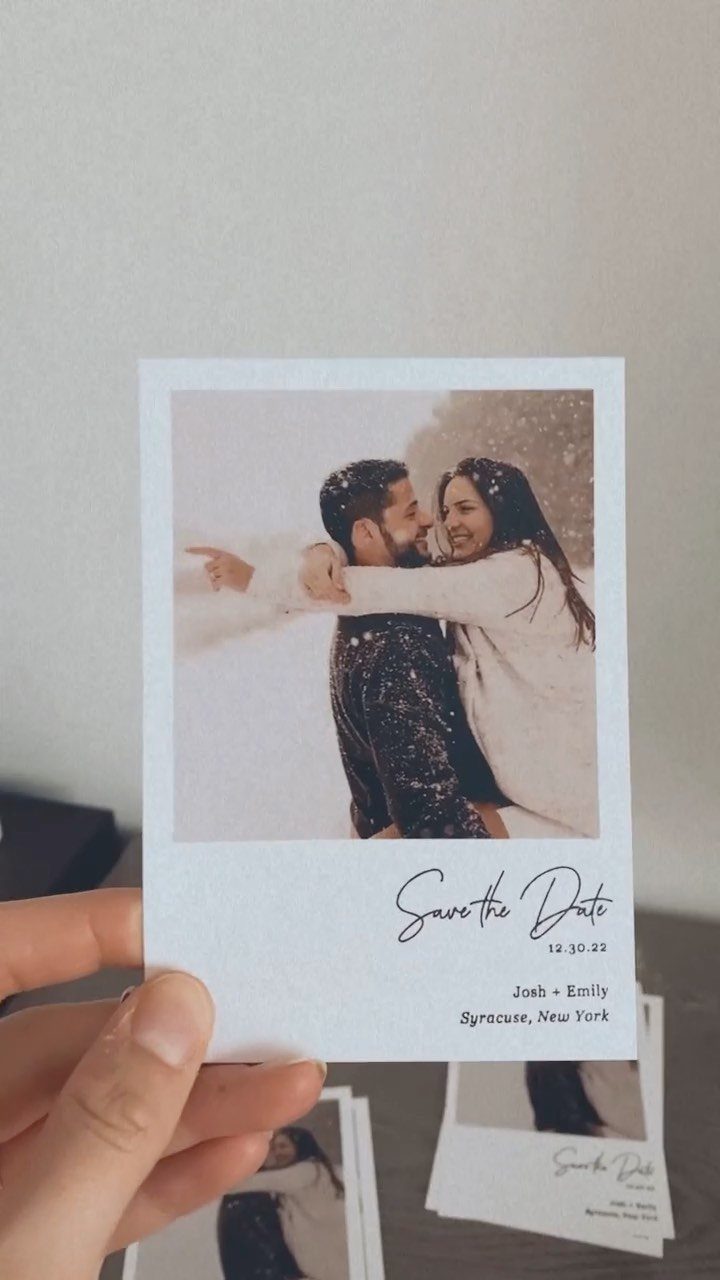 Polaroid style save the date card featuring a couple hugging in the snow.
