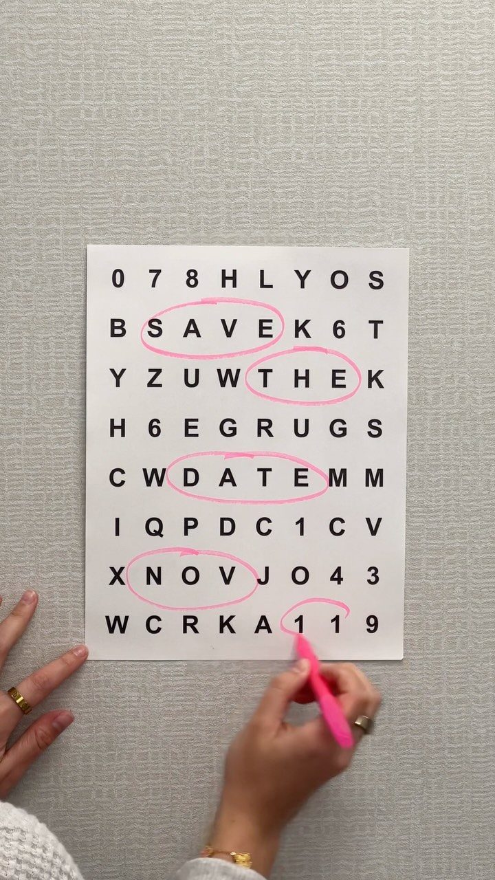 Hand circling words in a save the date word search puzzle with pink highlighter