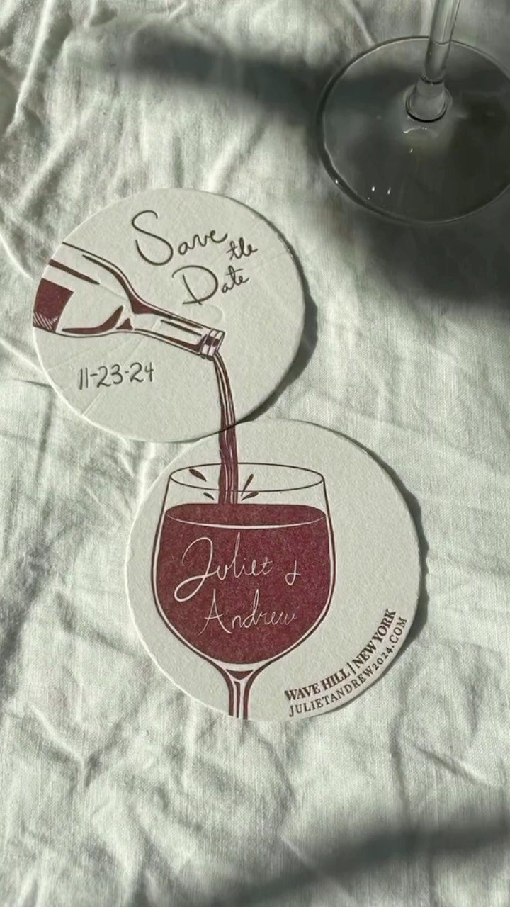 Two circular white coasters with a red wine pouring illustration and wedding text.