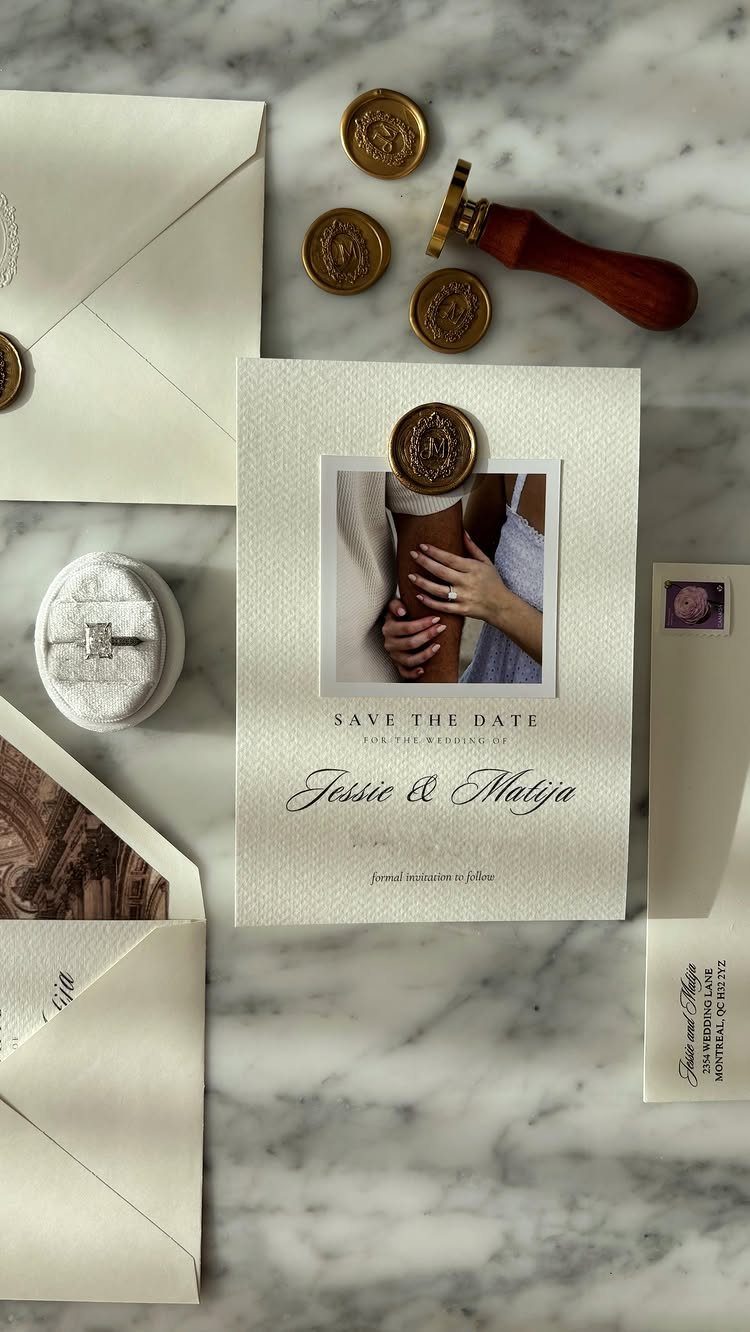 Save the date card with a gold wax seal on a marble surface.