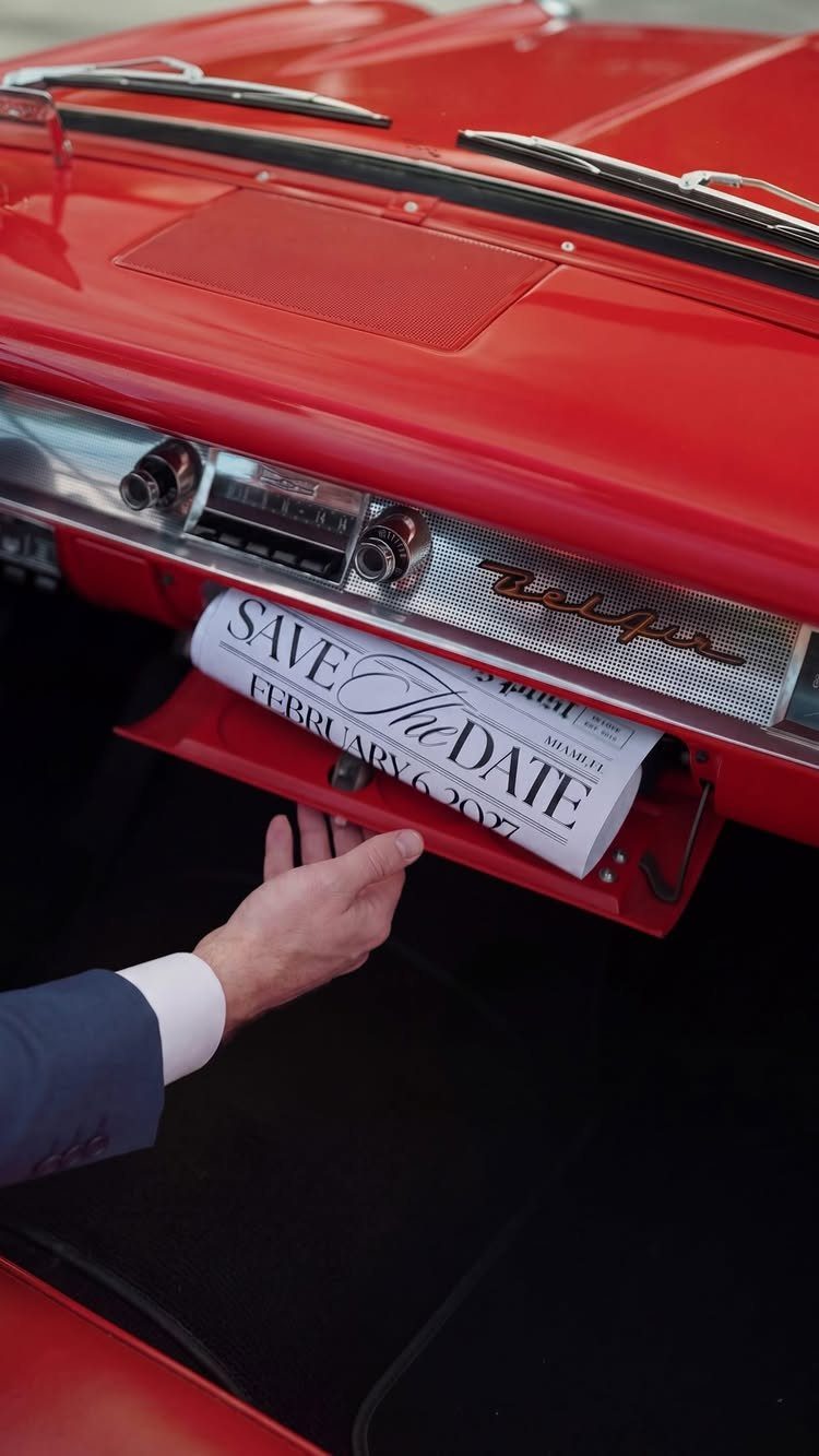 Save the date card in the glove box of a red vintage car