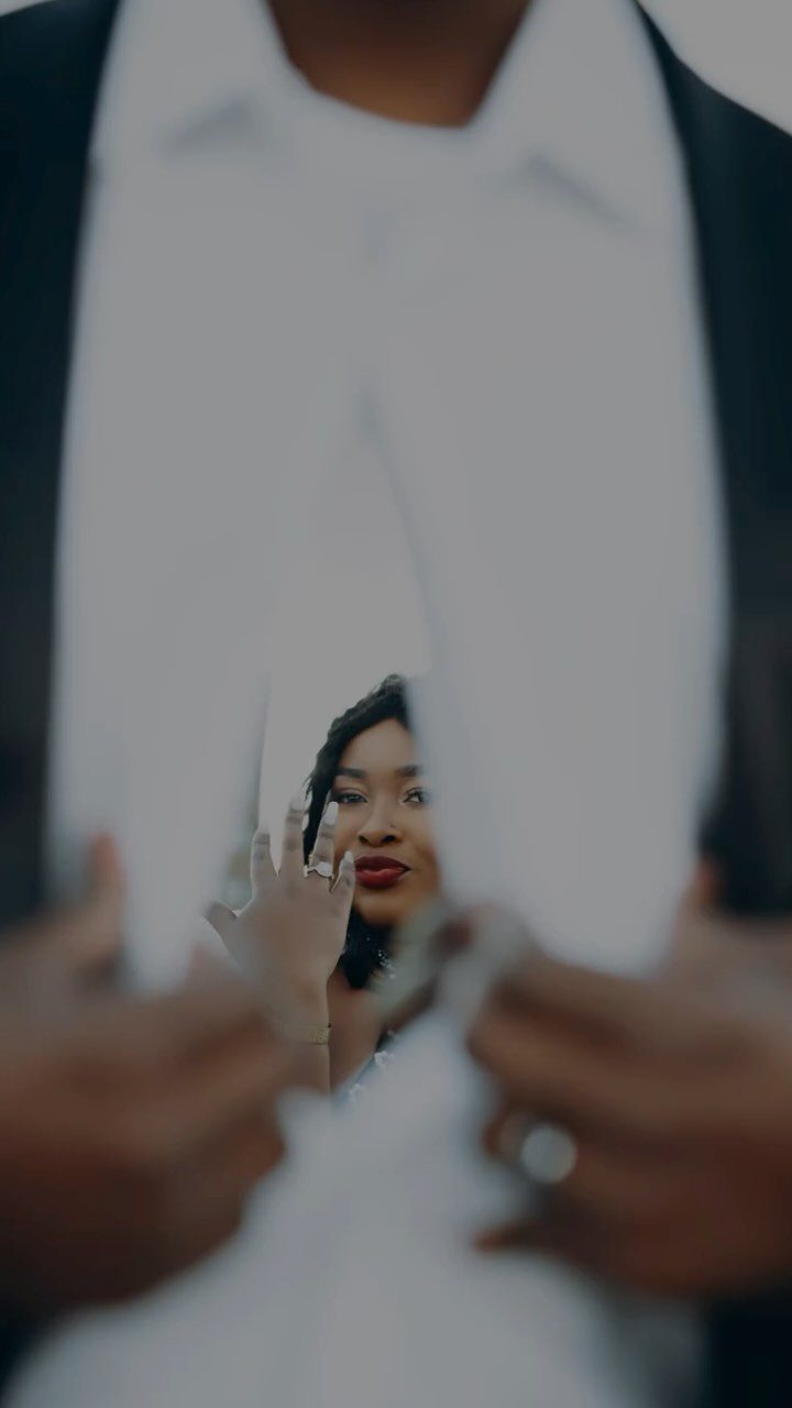 Mirror shard held by a man reflecting a woman in a white dress