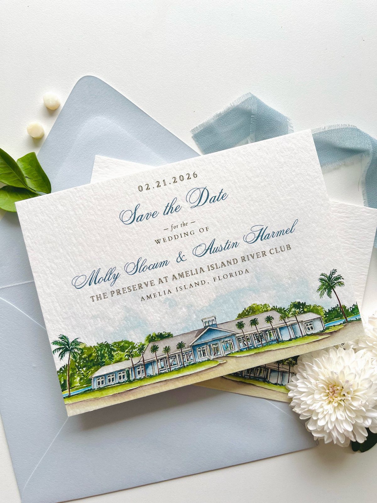 Save the date card with a watercolor illustration of a wedding venue building.