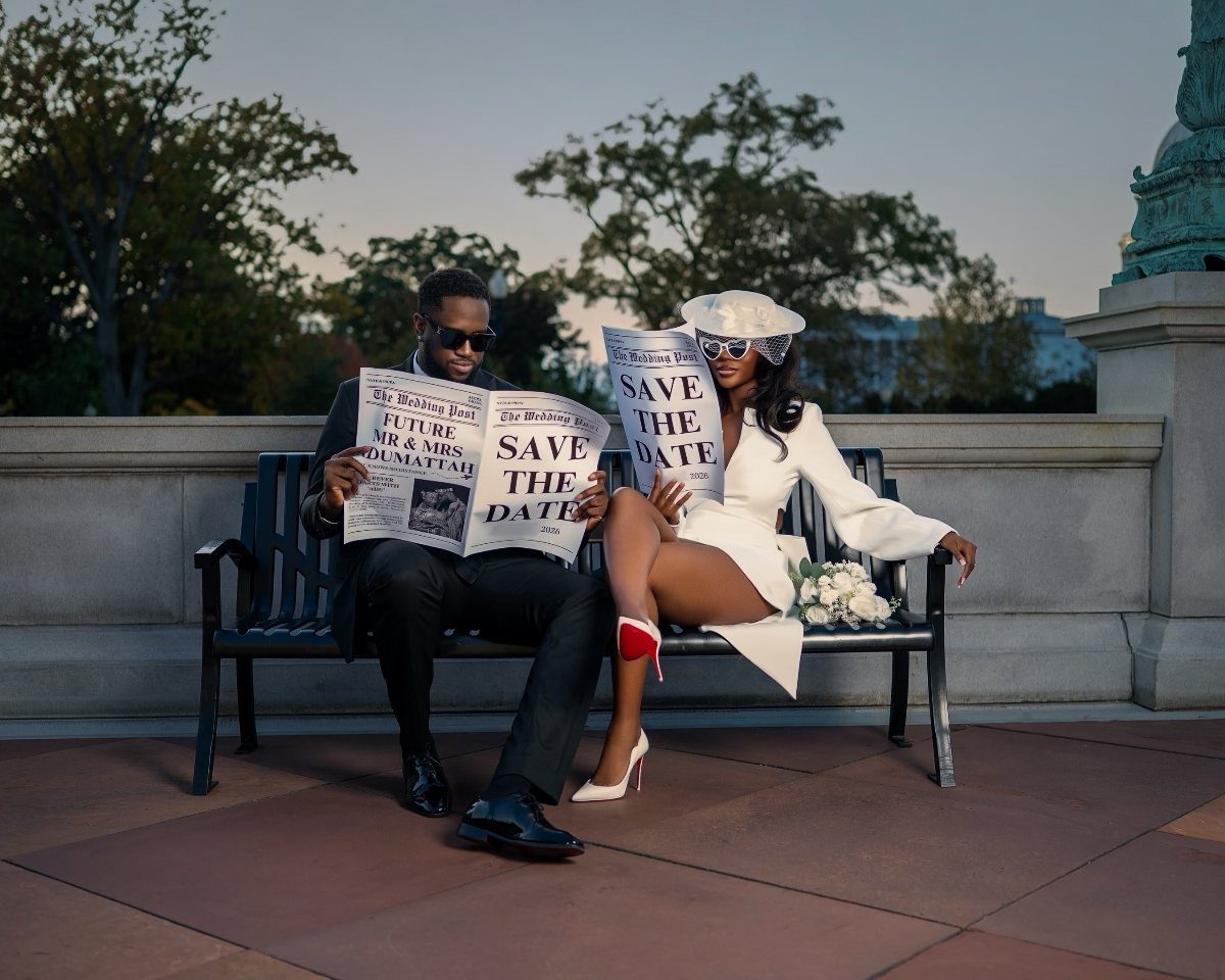 Couple sitting on a park bench holding save the date newspapers
