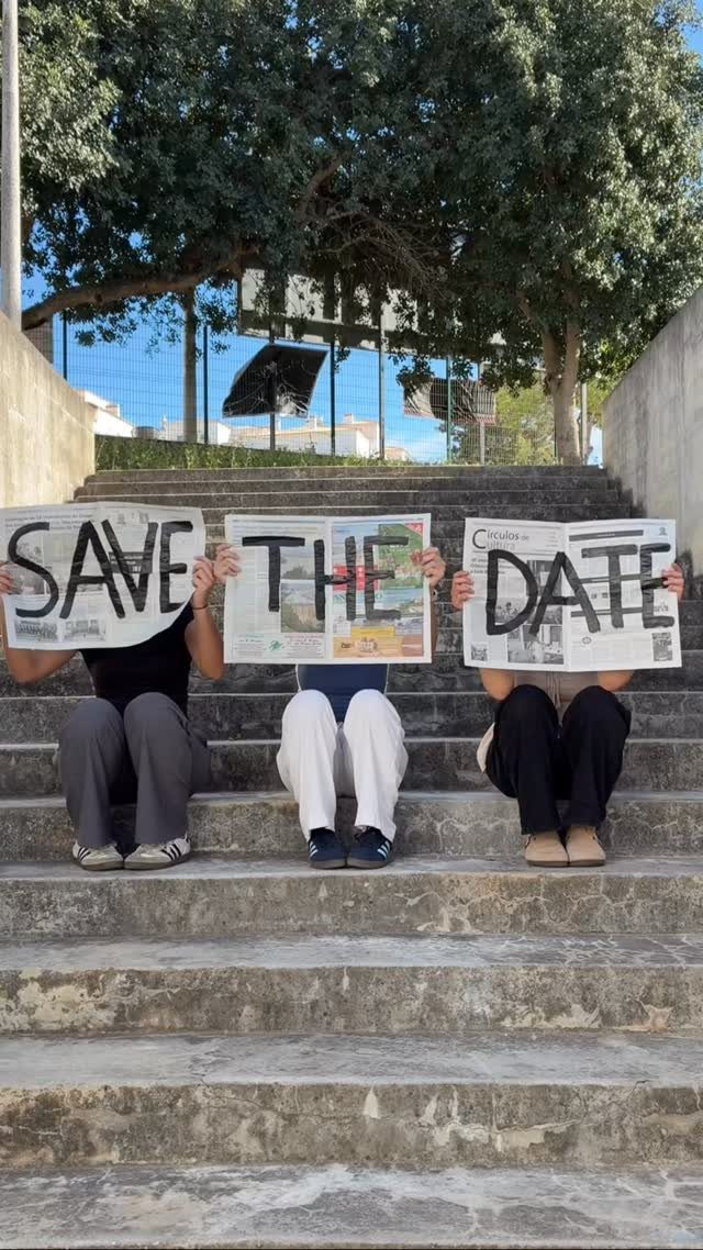 Three people sitting on stairs holding newspaper pages spelling SAVE THE DATE