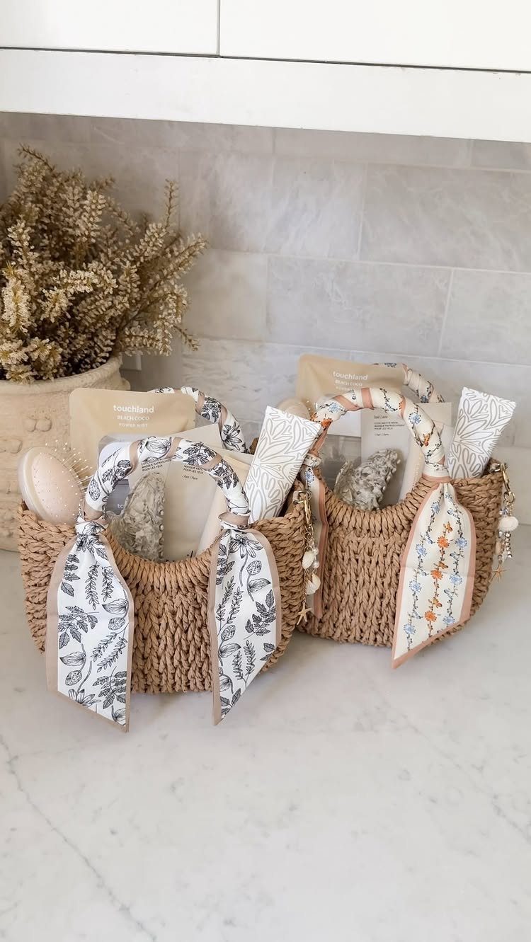 Two woven straw gift baskets filled with skincare products and decorated with ribbons.