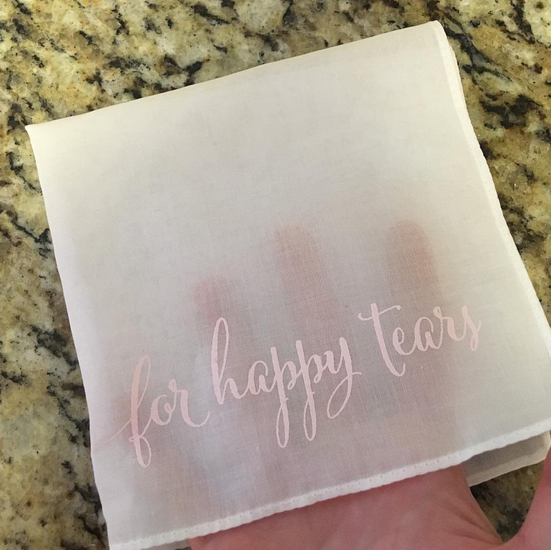 White fabric handkerchief with pink cursive text reading for happy tears