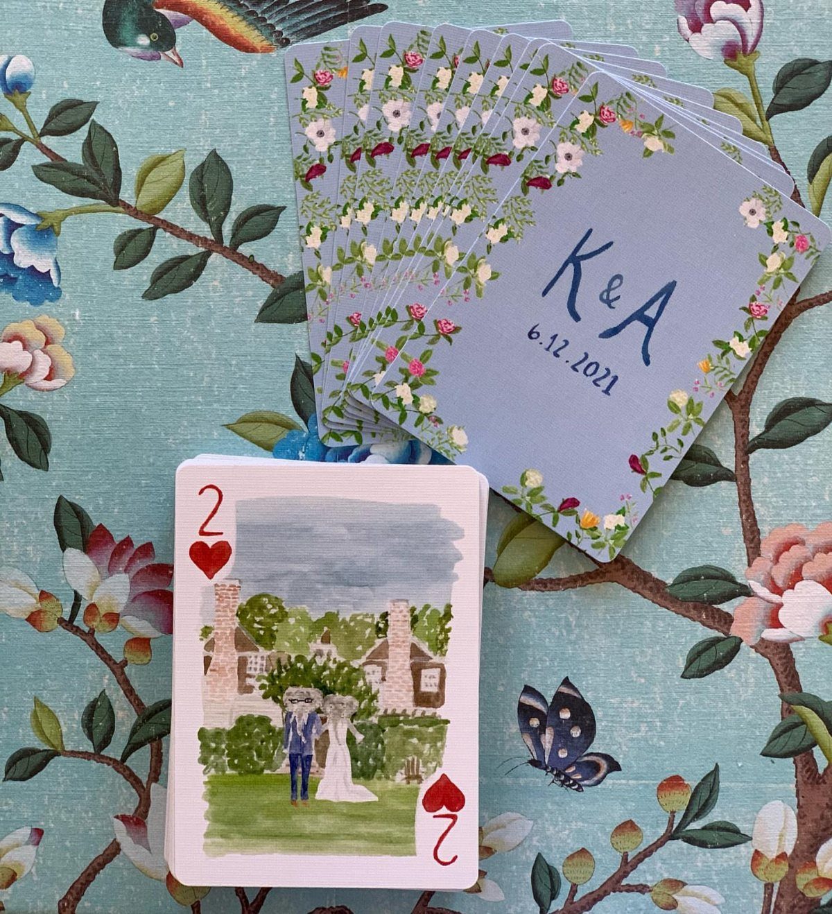 Custom wedding playing cards with watercolor couple illustration and floral monogrammed backs.