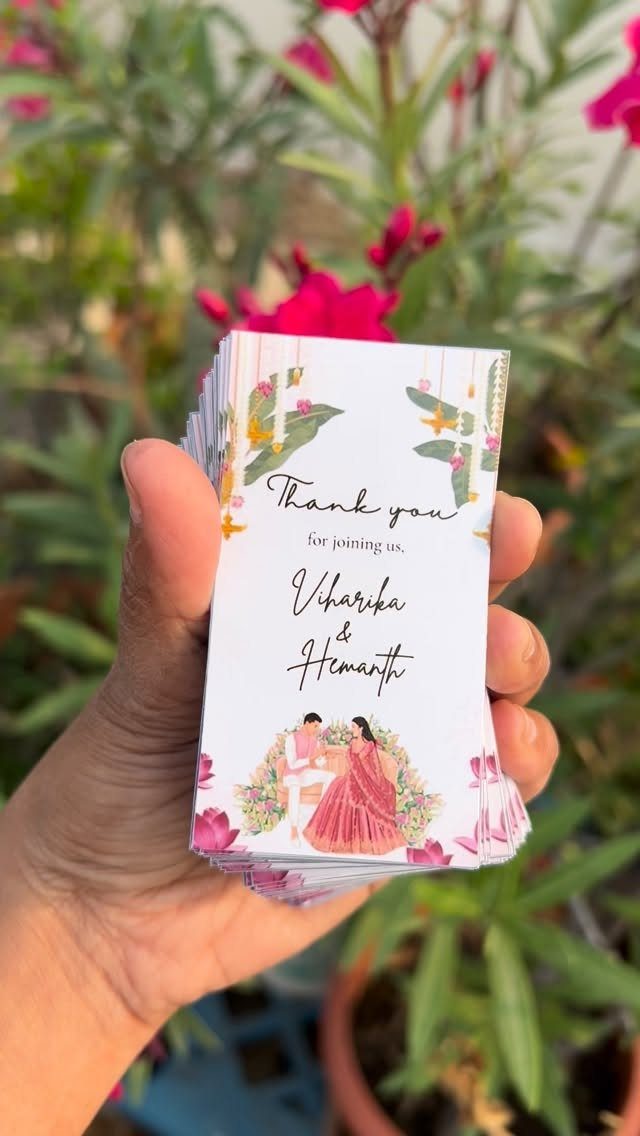 Stack of wedding thank you cards with floral designs and a couple illustration.