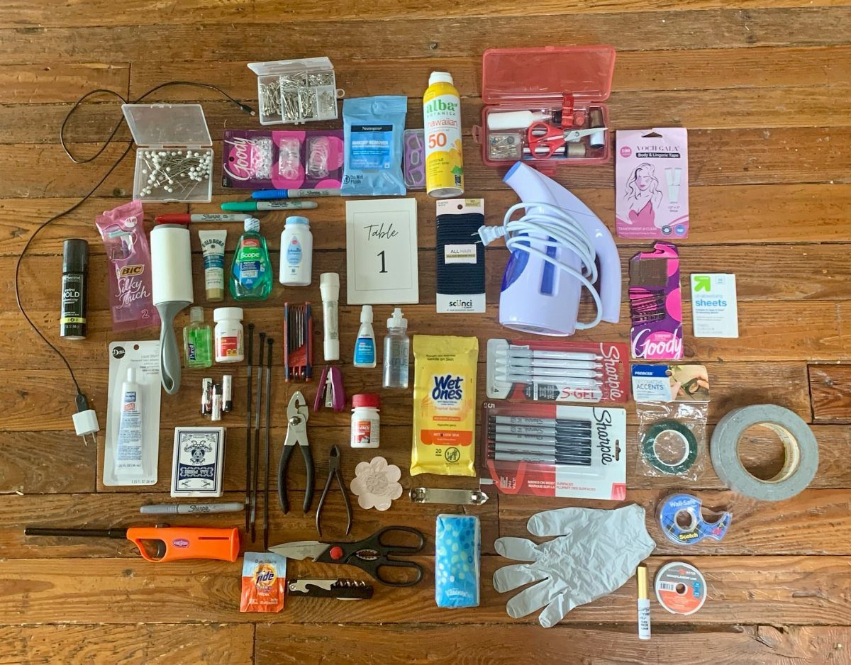 Emergency kit supplies including a steamer, sewing tools, and toiletries on wooden flooring.
