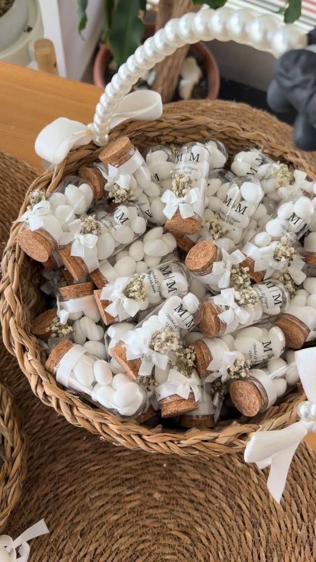 Wicker basket filled with small glass vials of white candies and dried flowers.