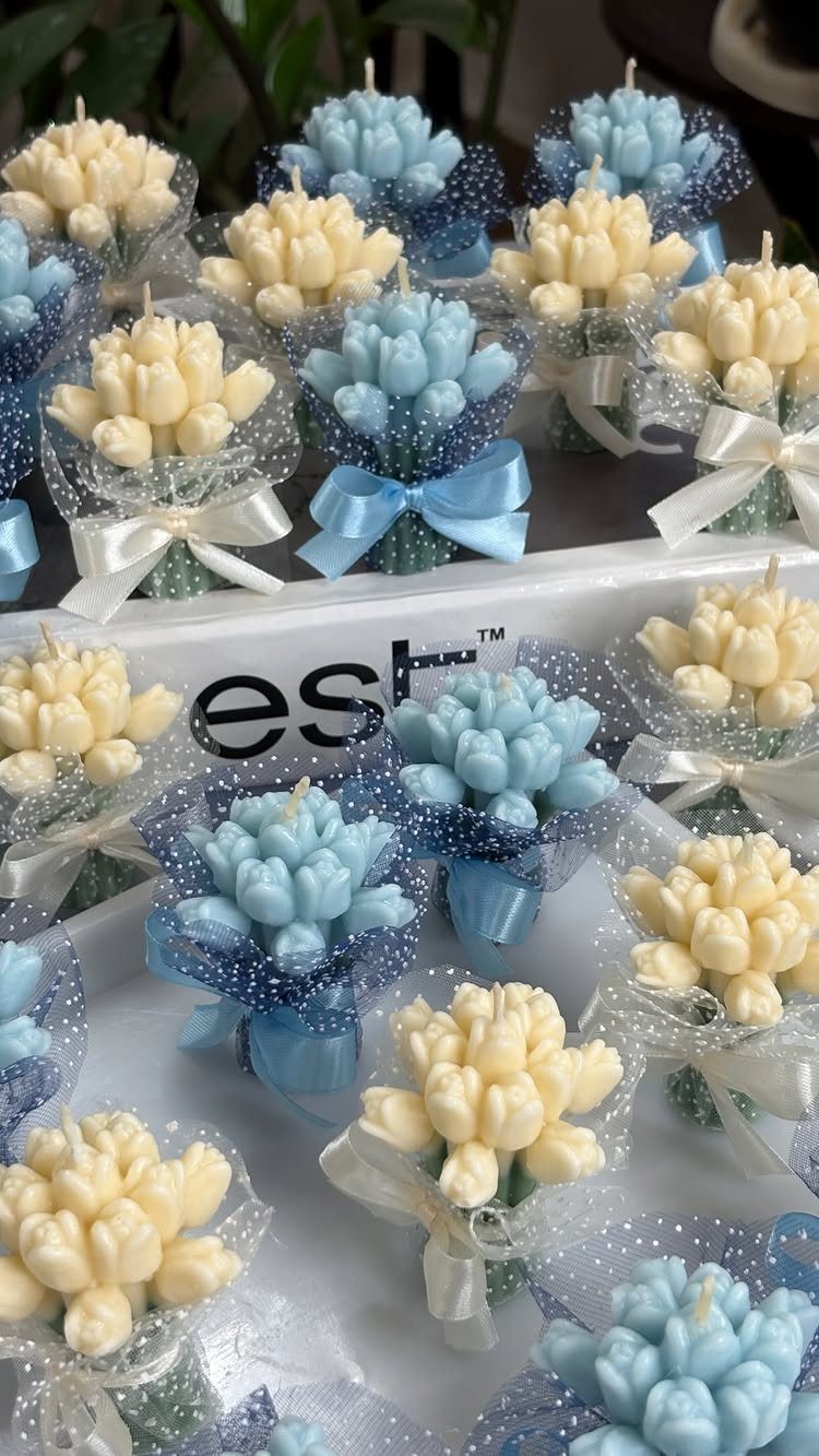 Bouquet-shaped candles in blue and cream wrapped in glittery cellophane with ribbons.