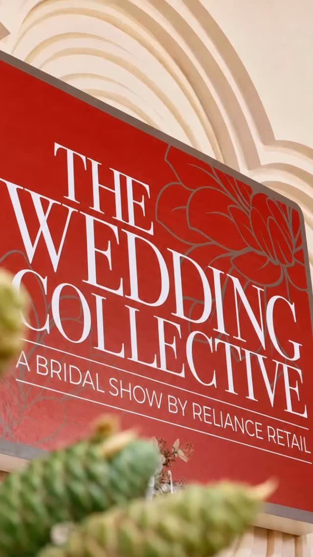 Red sign with white text reading The Wedding Collective at a bridal show.