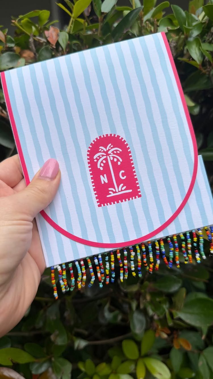 Striped blue and white wedding save the date card with pink accents and beaded fringe.