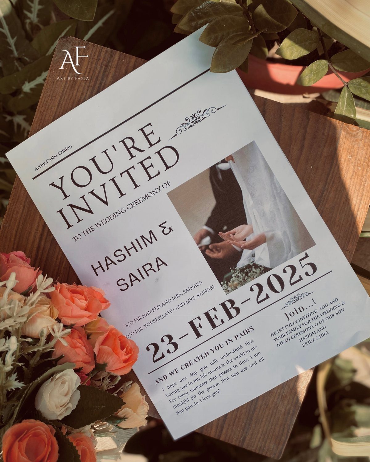 Wedding invitation card with a couple's photo and roses on a wooden surface