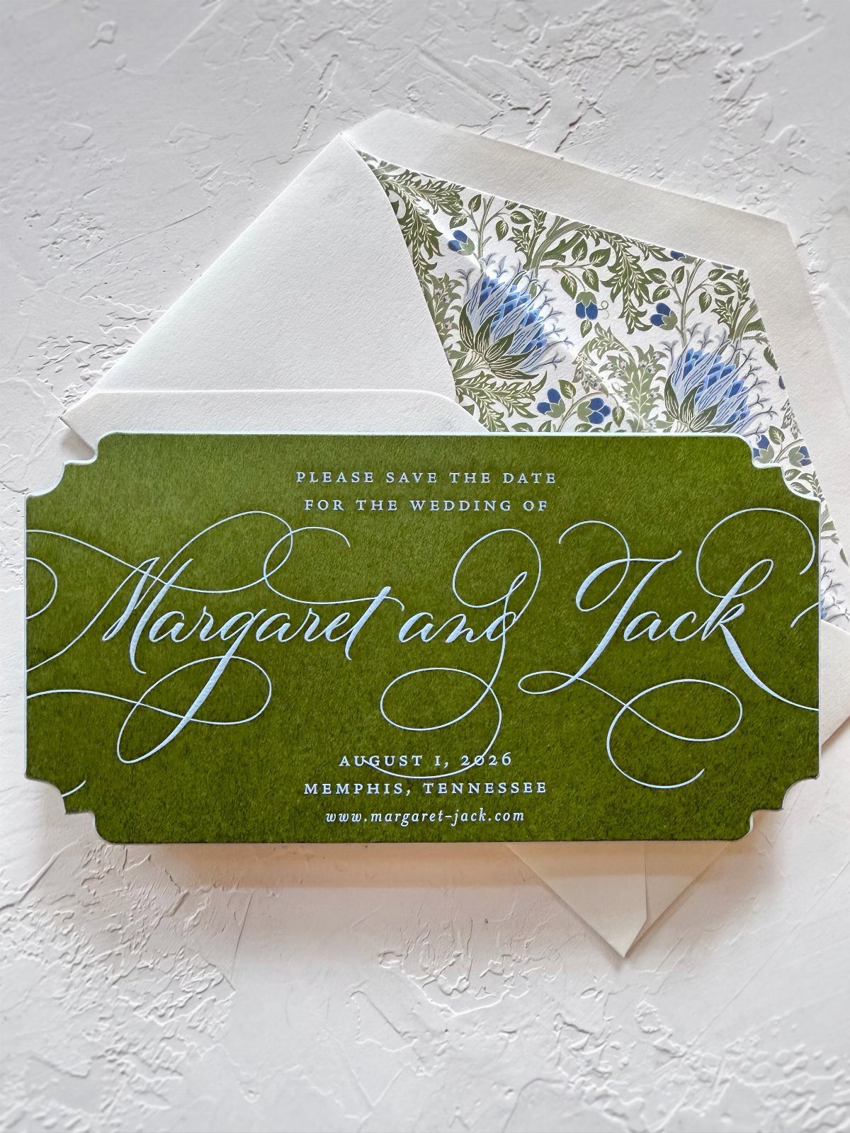 Olive green save the date card with white calligraphy and floral envelope liner.