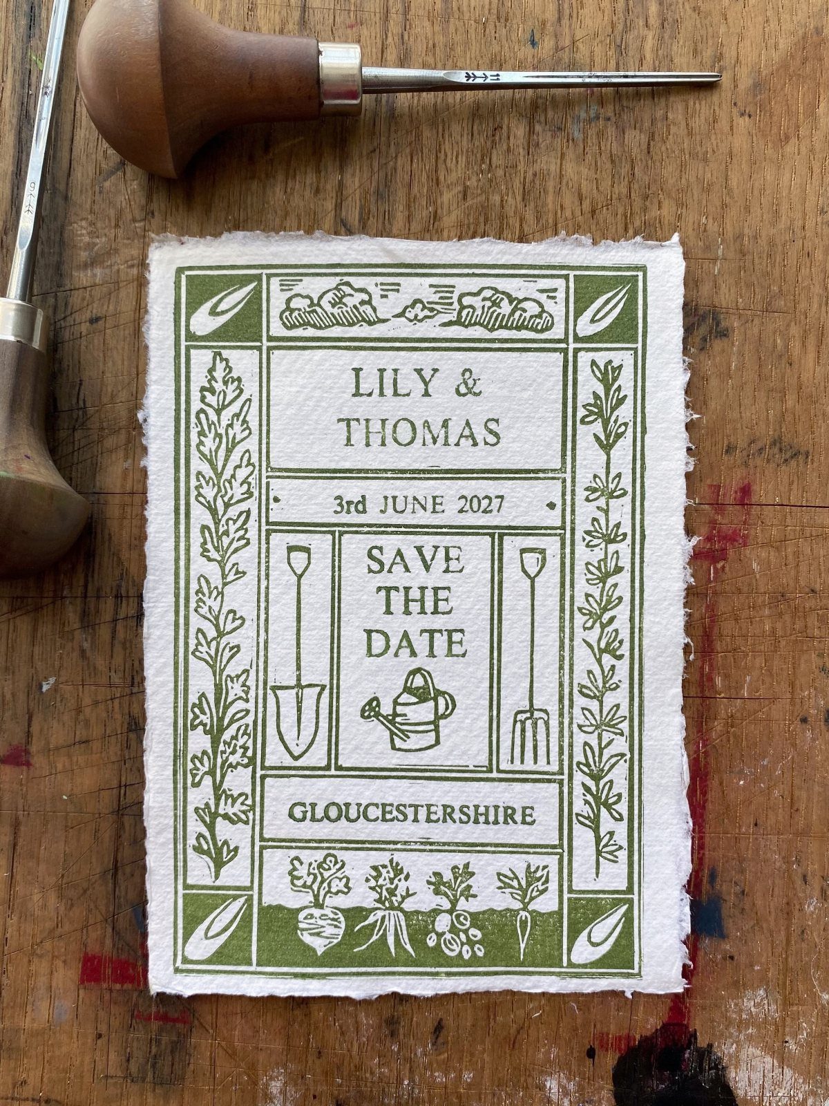 Rustic save the date card with green botanical illustrations on textured white paper.