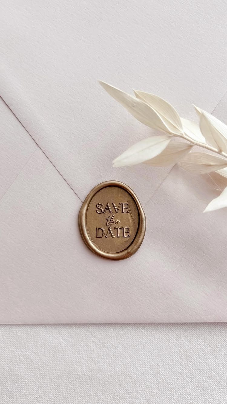Gold wax seal with Save the Date text on a pink envelope