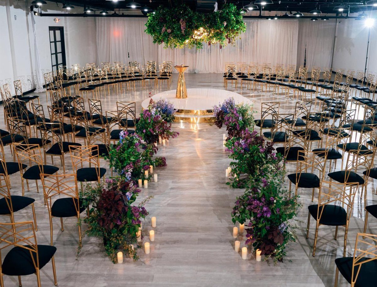 Gold wedding chairs arranged in a circle around a floral ceremony altar
