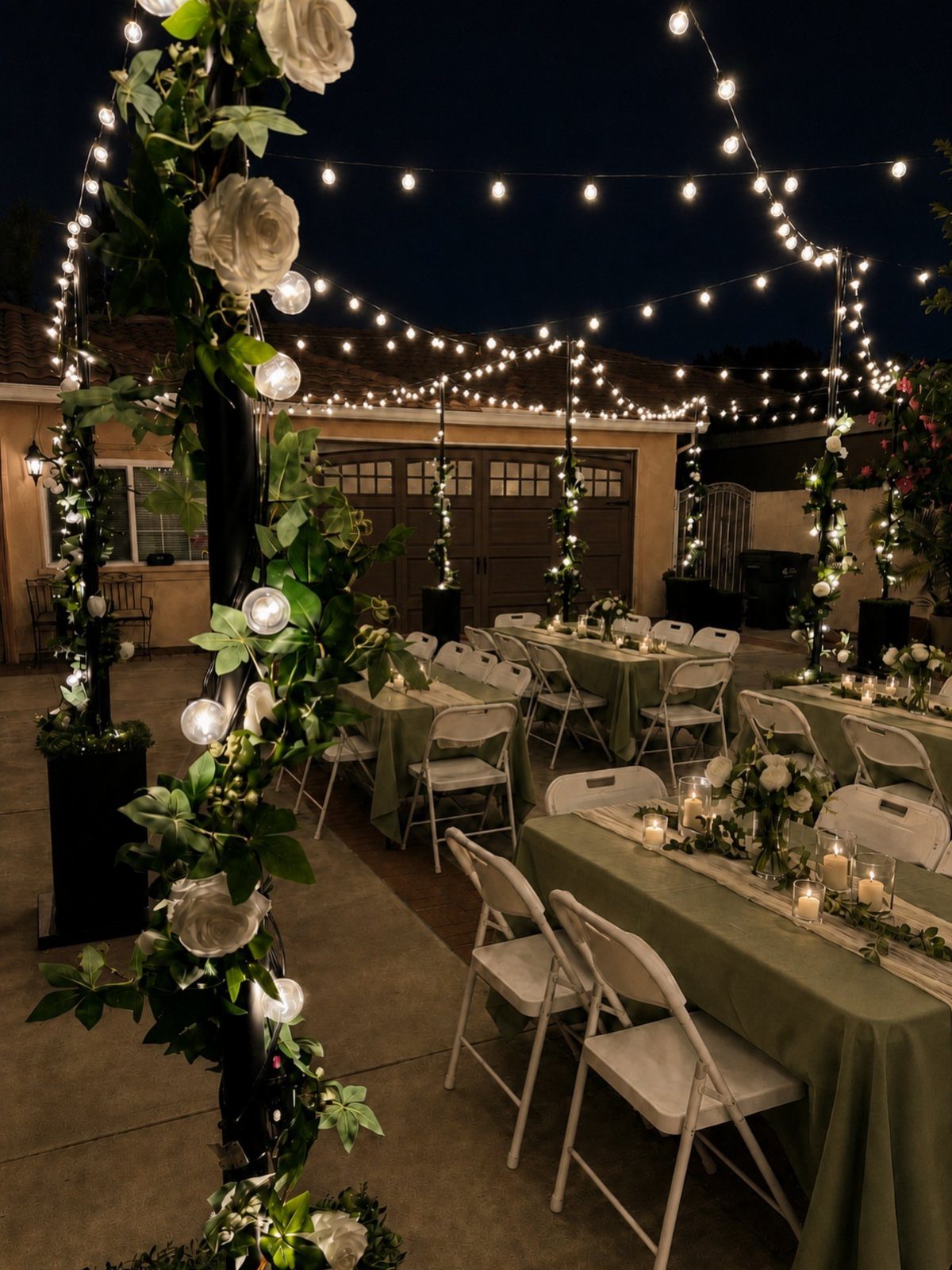 Outdoor wedding reception with green tables and warm string lights draped overhead at night.